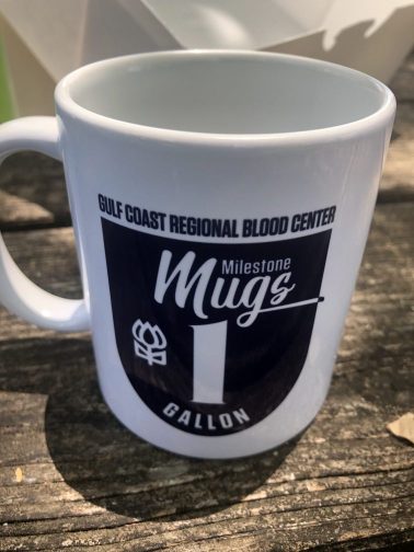 A coffee mug from the Gulf-Coast Regional Blood Center. It's a "Milestone Mug," give to those who have donated one gallon of material.